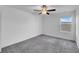 Bright bedroom with neutral carpet, a ceiling fan, and street view at 9893 Branching Ship Trce, Wesley Chapel, FL 33545