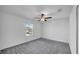 Cozy bedroom featuring a ceiling fan with light and a view of the neighborhood through the window at 9893 Branching Ship Trce, Wesley Chapel, FL 33545