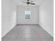 Minimalist bedroom featuring neutral tile floors, white walls, one window, and a ceiling fan at 9893 Branching Ship Trce, Wesley Chapel, FL 33545