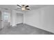 Bright bedroom features neutral walls, gray carpet, ceiling fan and closet at 9893 Branching Ship Trce, Wesley Chapel, FL 33545