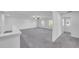 Open bedroom with neutral carpet, ceiling fan, two windows, and an open hallway at 9893 Branching Ship Trce, Wesley Chapel, FL 33545