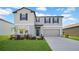 Charming two-story home with a well-manicured lawn and a two car garage on a sunny day at 9893 Branching Ship Trce, Wesley Chapel, FL 33545