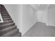 Hallway featuring stairs with carpet and tile flooring leading to the front door at 9893 Branching Ship Trce, Wesley Chapel, FL 33545