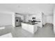 Kitchen with white cabinetry, granite counters and stainless appliances adjoins spacious, well-lit living area perfect for entertaining at 9893 Branching Ship Trce, Wesley Chapel, FL 33545