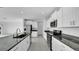 Well-equipped kitchen with white cabinets, granite countertops, and stainless steel appliances, combining functionality and elegance at 9893 Branching Ship Trce, Wesley Chapel, FL 33545