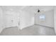 Open-concept living room with neutral tiles, white walls, and an entryway with a white front door at 9893 Branching Ship Trce, Wesley Chapel, FL 33545