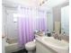 Cozy bathroom features a shower-tub combo, neutral counter and vanity with a large mirror, and purple decor at 10321 Ravines Dr, New Port Richey, FL 34654
