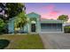 Charming single-story home with a well-maintained lawn, tropical landscaping, and a screened garage at 10321 Ravines Dr, New Port Richey, FL 34654
