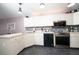Bright kitchen features white cabinets, stainless steel appliances, and mosaic tile backsplash at 10321 Ravines Dr, New Port Richey, FL 34654