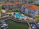 Aerial view of community pool, palm trees, docks, boat lifts, and waterways at 1042 Bellasol Way # 202, Apollo Beach, FL 33572