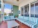 Outdoor balcony offering comfortable seating on a red tile floor with partial shutters at 1042 Bellasol Way # 202, Apollo Beach, FL 33572