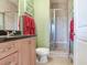 Bathroom showcasing a shower with glass door, single vanity, and neutral tile flooring at 1042 Bellasol Way # 202, Apollo Beach, FL 33572