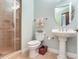 Bathroom showcasing a pedestal sink, walk-in shower, and neutral tile flooring at 1042 Bellasol Way # 202, Apollo Beach, FL 33572