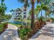 Well-maintained building exterior with a serene pond, fountain, and lush landscaping at 1042 Bellasol Way # 202, Apollo Beach, FL 33572