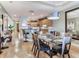Open concept dining area features a glass table, wood floors, and seamless flow to the kitchen at 1042 Bellasol Way # 202, Apollo Beach, FL 33572
