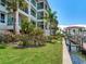 Exterior of building featuring a waterfront dock and multiple balconies with trees at 1042 Bellasol Way # 202, Apollo Beach, FL 33572