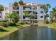 Condo exterior featuring an appealing pond, lush landscaping and convenient parking at 1042 Bellasol Way # 202, Apollo Beach, FL 33572