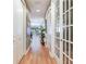 Hallway with wood floors, white trim, and open view to the living area at 1042 Bellasol Way # 202, Apollo Beach, FL 33572