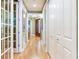 Inviting hallway featuring hardwood floors, white trim, and a glimpse of the home's interior design at 1042 Bellasol Way # 202, Apollo Beach, FL 33572