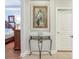 Hallway with a decorative table, artwork and a glimpse into the bedroom at 1042 Bellasol Way # 202, Apollo Beach, FL 33572