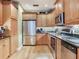 Spacious kitchen featuring stainless steel appliances, tile backsplash, ample wood cabinetry, and granite countertops at 1042 Bellasol Way # 202, Apollo Beach, FL 33572