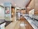 Well-lit kitchen boasts stainless steel appliances, mosaic backsplash, granite countertops, and light wood cabinetry at 1042 Bellasol Way # 202, Apollo Beach, FL 33572