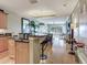 Open-concept floor plan with kitchen island, dining area, and living room featuring hard wood flooring and natural light at 1042 Bellasol Way # 202, Apollo Beach, FL 33572