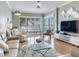 The cozy living room features modern furniture, light wood floors and a beautiful waterfront view at 1042 Bellasol Way # 202, Apollo Beach, FL 33572