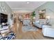 Open-concept living space with modern furniture, wood floors, and seamless flow to the kitchen at 1042 Bellasol Way # 202, Apollo Beach, FL 33572