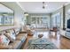 Cozy living room features wood floors, an area rug, and a piano by the window at 1042 Bellasol Way # 202, Apollo Beach, FL 33572