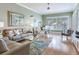 Bright living room with hardwood floors, neutral furniture, and a large window with plantation shutters at 1042 Bellasol Way # 202, Apollo Beach, FL 33572