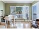 Living area with a white piano, plantation shutters and serene water views at 1042 Bellasol Way # 202, Apollo Beach, FL 33572