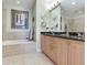 The main bathroom features double sinks, tile flooring, built in bathtub, and a shower at 1042 Bellasol Way # 202, Apollo Beach, FL 33572