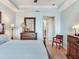 A charming main bedroom features wooden floors, soft colors, and an ensuite bathroom at 1042 Bellasol Way # 202, Apollo Beach, FL 33572