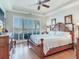 This main bedroom features wood furniture, wood floors, and natural light from sliding glass doors to the balcony at 1042 Bellasol Way # 202, Apollo Beach, FL 33572