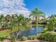 Picturesque pond with fountain feature, surrounded by lush tropical landscaping at 1042 Bellasol Way # 202, Apollo Beach, FL 33572