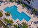 Aerial view of a large community pool with palm trees and lounge chairs at 1042 Bellasol Way # 202, Apollo Beach, FL 33572