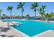 Large and inviting pool area offering waterfront views and swaying palms at 1042 Bellasol Way # 202, Apollo Beach, FL 33572