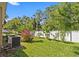 Landscaped backyard with green grass, trees and white fence at 10514 Scenic Hollow Dr, Riverview, FL 33578