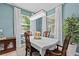 Bright dining room featuring a decorative chandelier, wooden dining set, and natural light from the large window at 10514 Scenic Hollow Dr, Riverview, FL 33578
