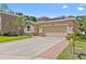 Charming single-Gathering home featuring a well-manicured lawn and a brick-lined driveway leading to a spacious two-car garage at 10514 Scenic Hollow Dr, Riverview, FL 33578