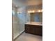 Modern bathroom featuring double vanity, walk-in shower with glass door, and decorative lighting at 10712 Oak Bend Dr, Parrish, FL 34219