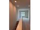 Upstairs hallway leads to a sun-filled room with neutral carpet, and bright windows at 10712 Oak Bend Dr, Parrish, FL 34219