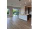 Open floor plan reveals island kitchen, stainless appliances, and sliding doors to the backyard at 10712 Oak Bend Dr, Parrish, FL 34219