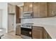 Modern kitchen featuring stainless steel appliances, wood cabinetry, and quartz countertops at 10712 Oak Bend Dr, Parrish, FL 34219