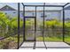 View of a screened-in patio area with a door, concrete flooring, and a backyard view at 10712 Oak Bend Dr, Parrish, FL 34219
