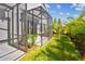 A screened-in patio featuring lush landscaping and a view of the home's exterior at 10712 Oak Bend Dr, Parrish, FL 34219