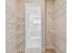 View of a walk-in closet with installed shelving units and a view of a bathroom through the doorway at 10712 Oak Bend Dr, Parrish, FL 34219