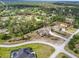 Aerial view of a home with a pool, lush landscaping, and a circular driveway in a wooded neighborhood at 11296 Warm Wind Way, Weeki Wachee, FL 34613