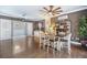 Open-concept dining room with hardwood floors, white wooden chairs, and modern light fixtures at 11296 Warm Wind Way, Weeki Wachee, FL 34613